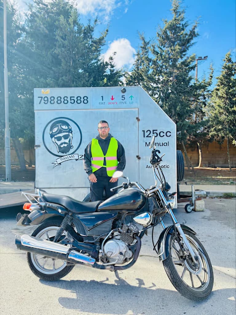 125cc motorcycle beside a Mariani-branded training trailer